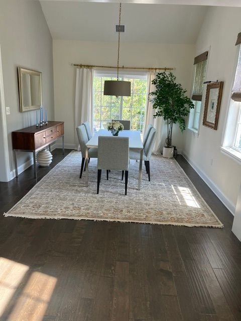 A dining room with a full table setting and a tall tree in the corner